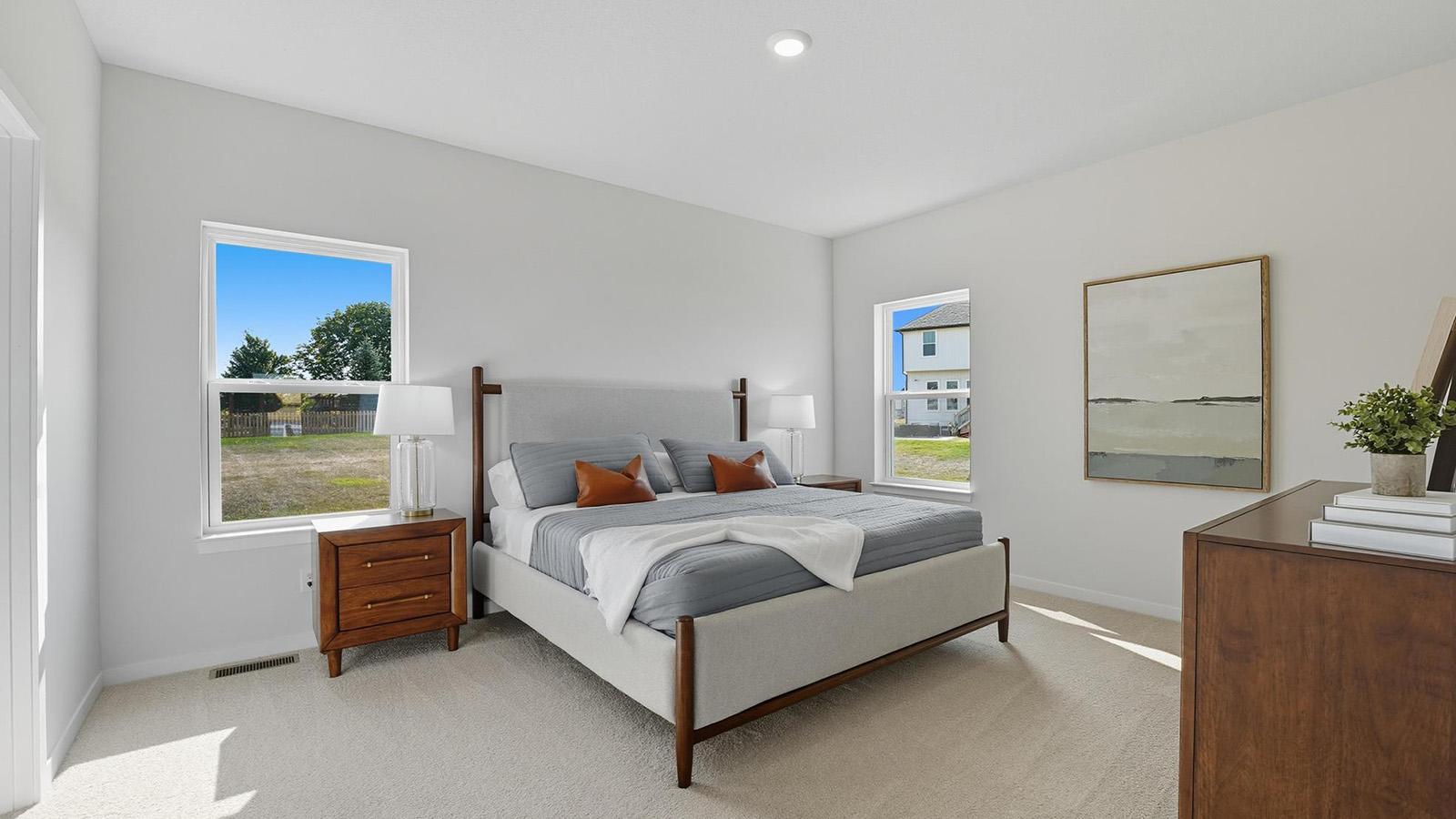 Carpeted primary bedroom with large windows.