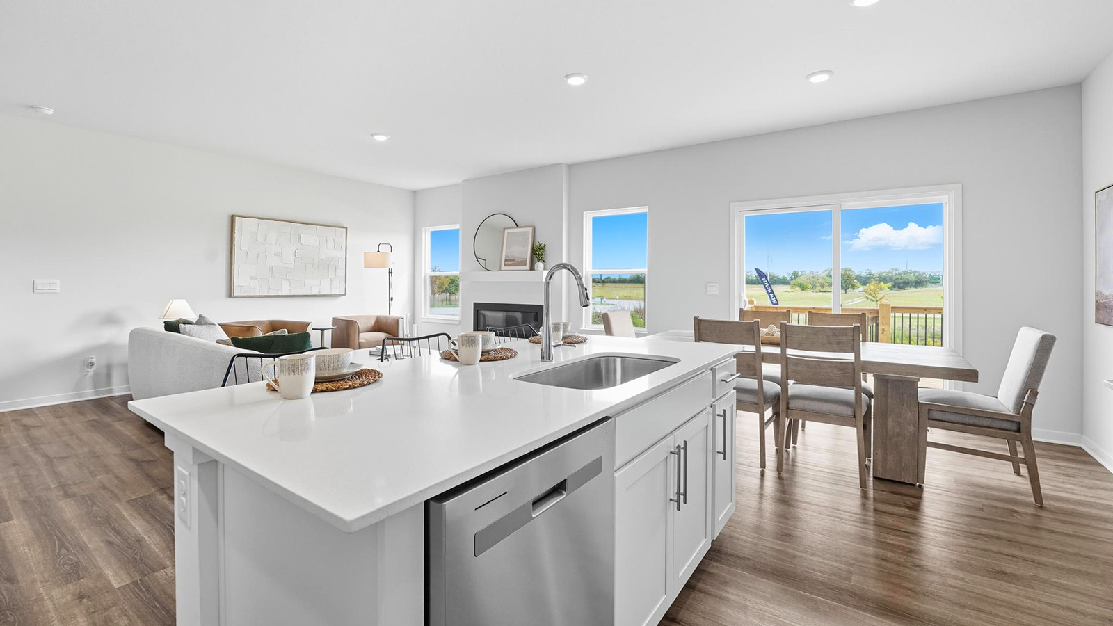 Open-concept kitchen with white counters and cabinets, and stainless steel appliances.