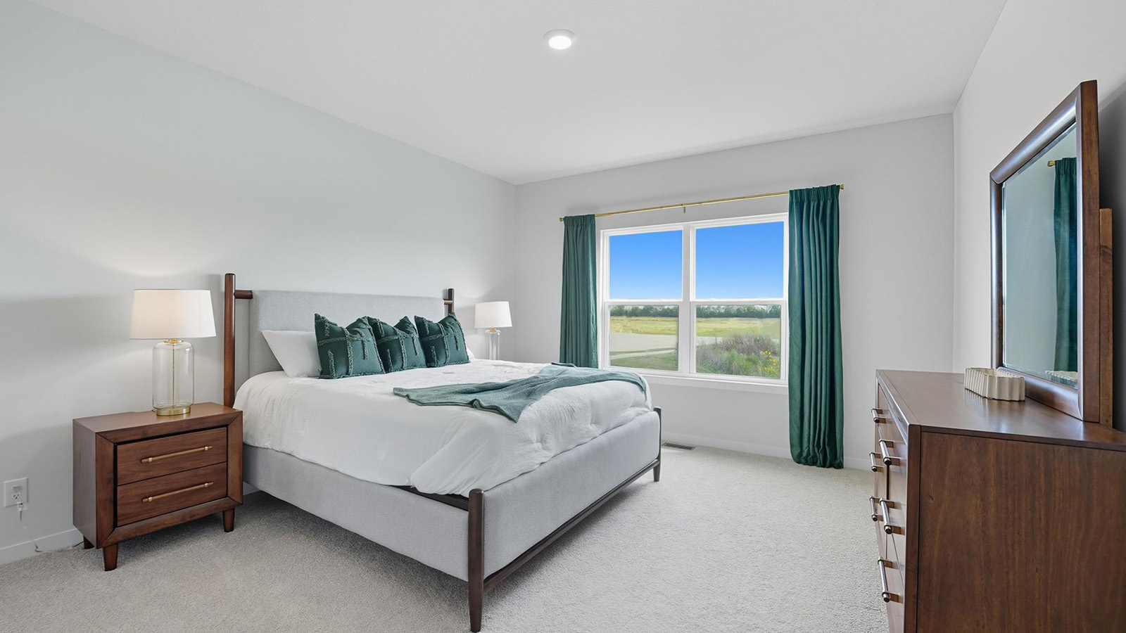 Primary carpeted bedroom with large windows.