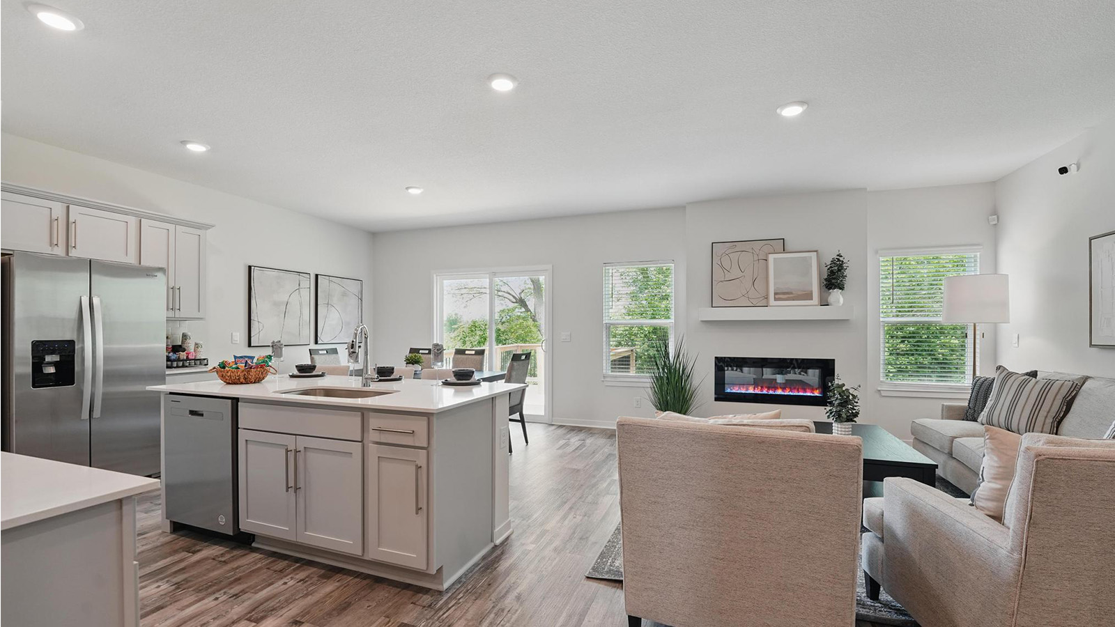 Kitchen and island with white cabinets and stainless steel appliances.