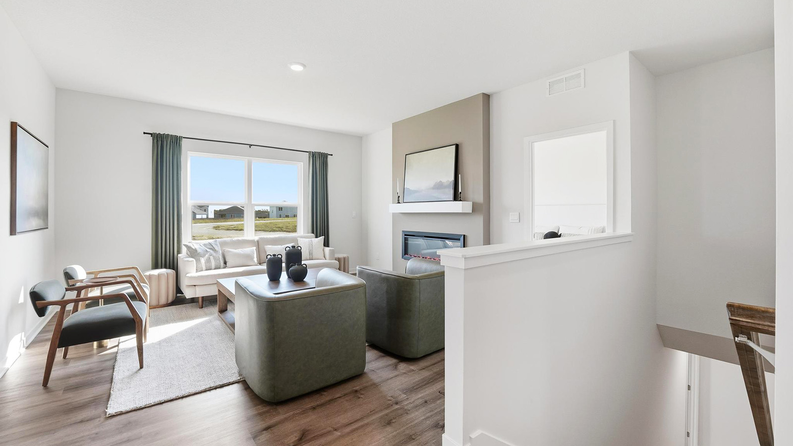 Living room beside kitchen, with electric fireplace and large window