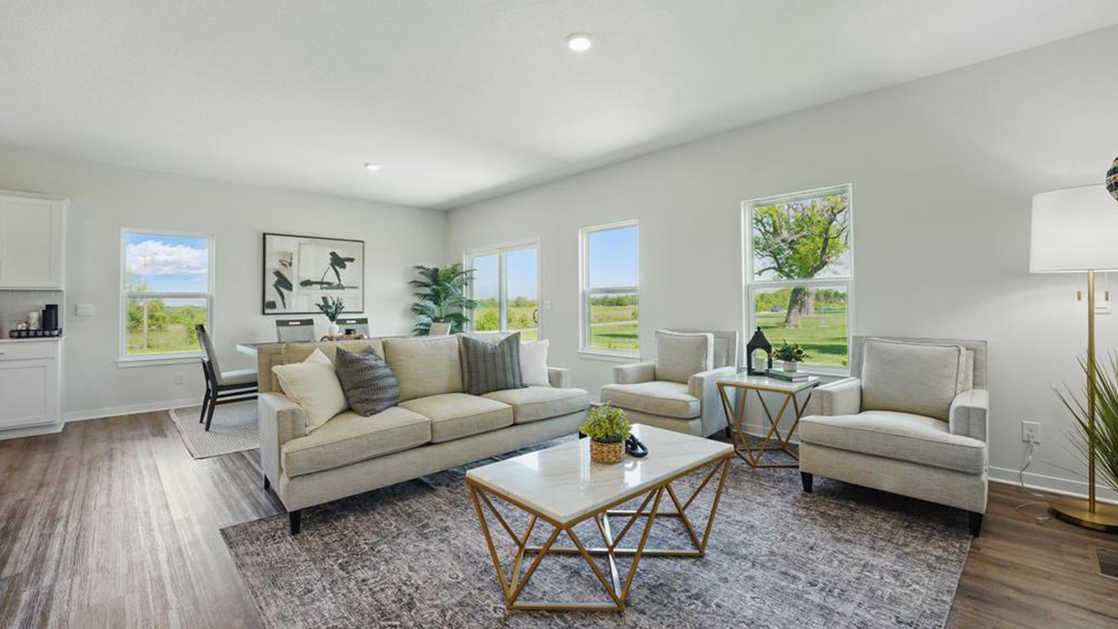 Living room with electric fireplace and two large windows, beside kitchen and dining area