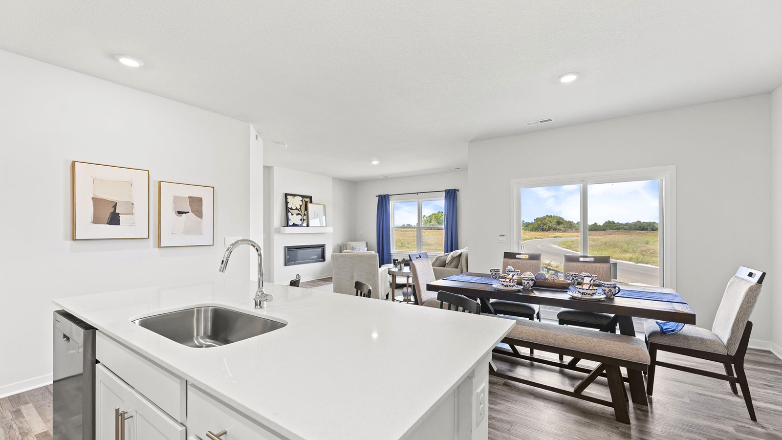 Kitchen and island with white cabinets, tile backsplash, and stainless steel appliances