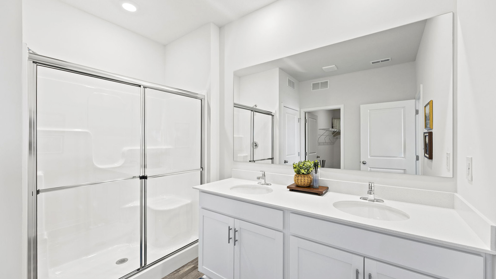 Bathroom with double vanity and shower with glass door