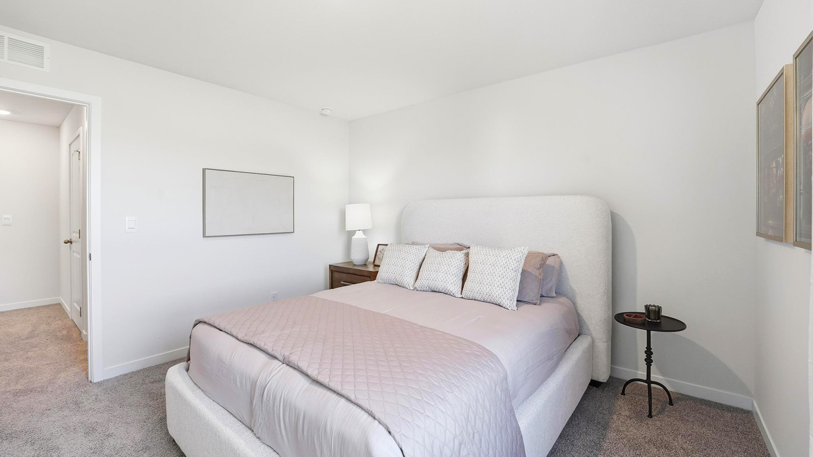 Carpeted bedroom with large window.