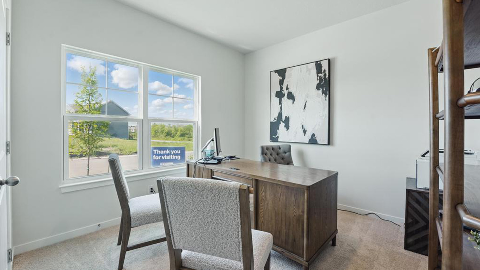 Carpeted bedroom used as office with large window