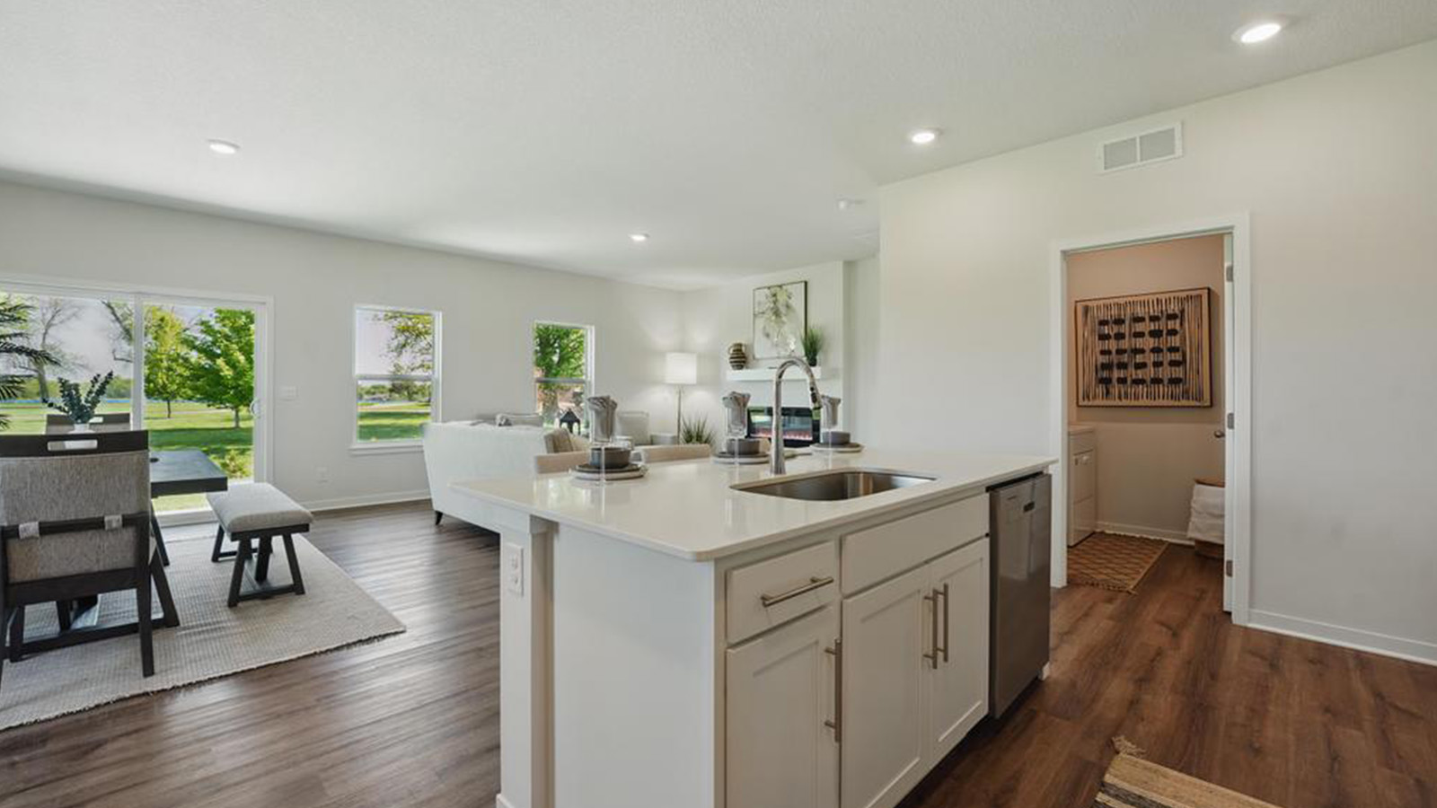 Open concept kitchen with large island, white cabinets and countertops, and stainless steel appliances