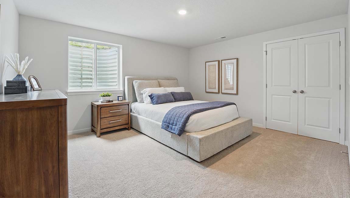 Carpeted bedroom with large window.