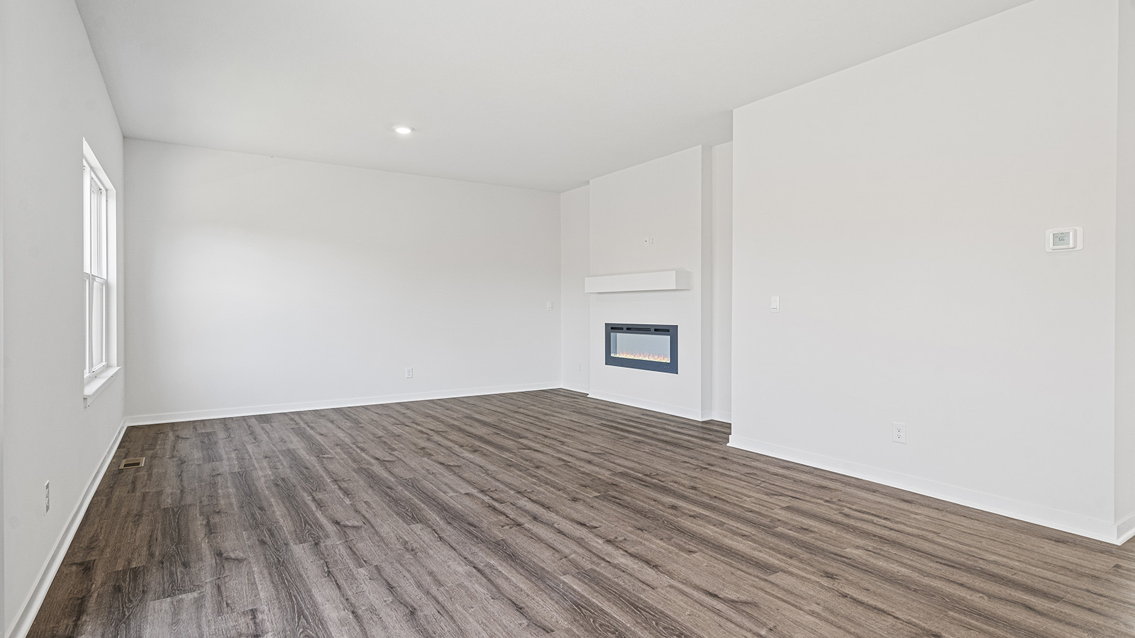 Open concept living area with electric fireplace and large window
