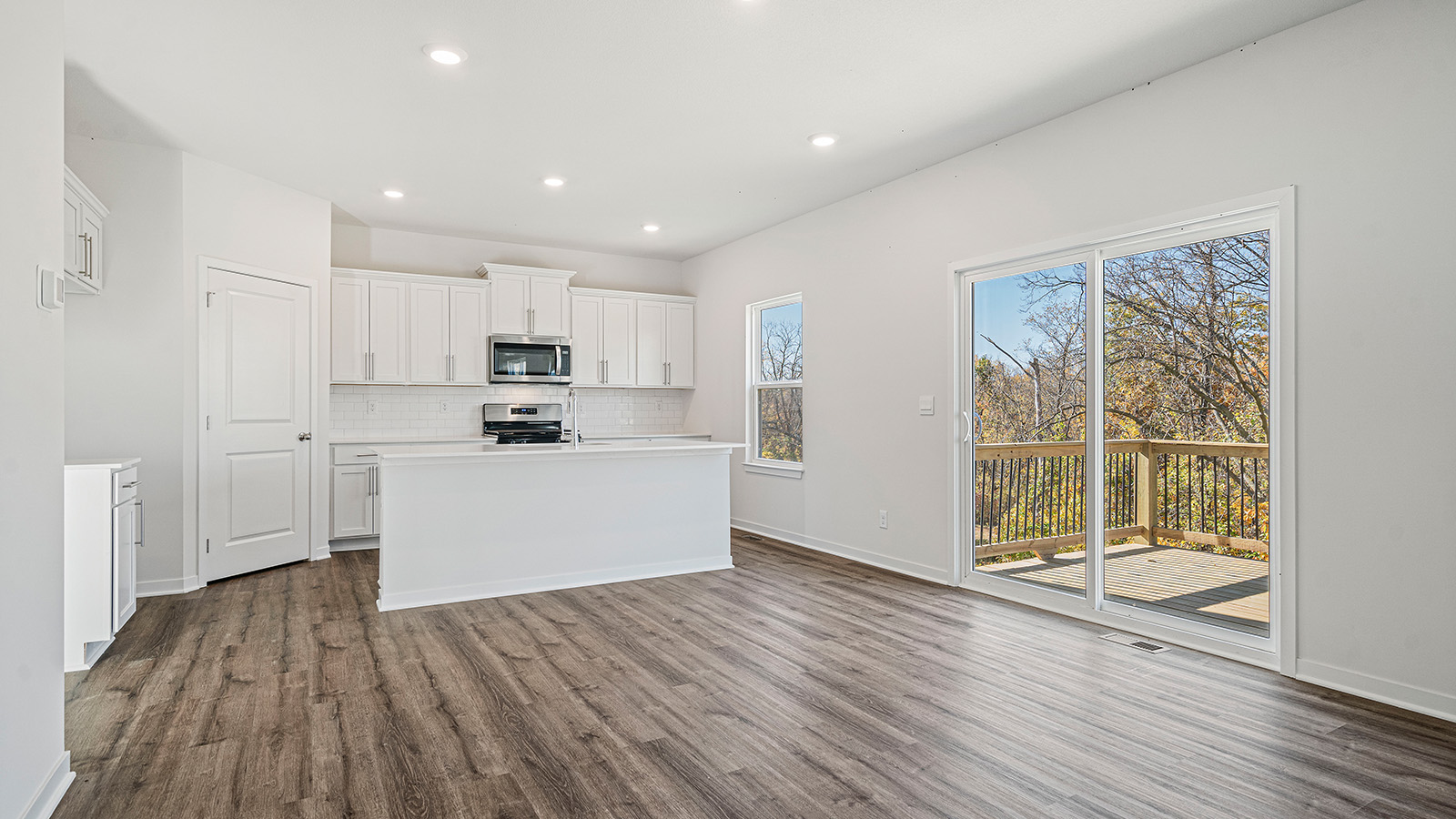 Living room beside kitchen, with electric fireplace and large windows