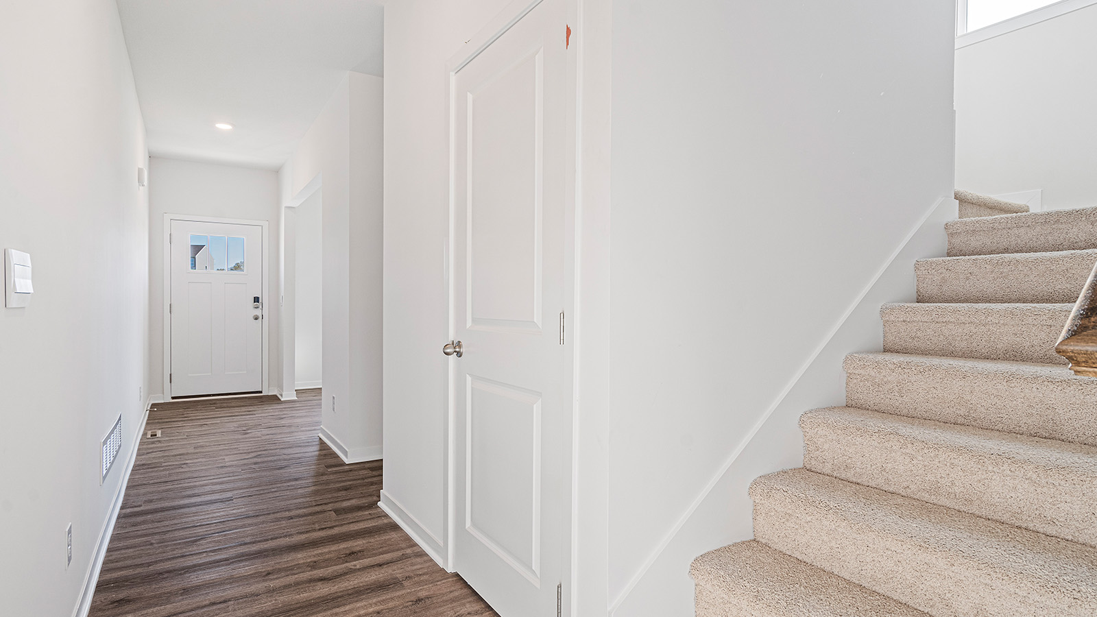 Welcoming foyer with view of carpeted staircase
