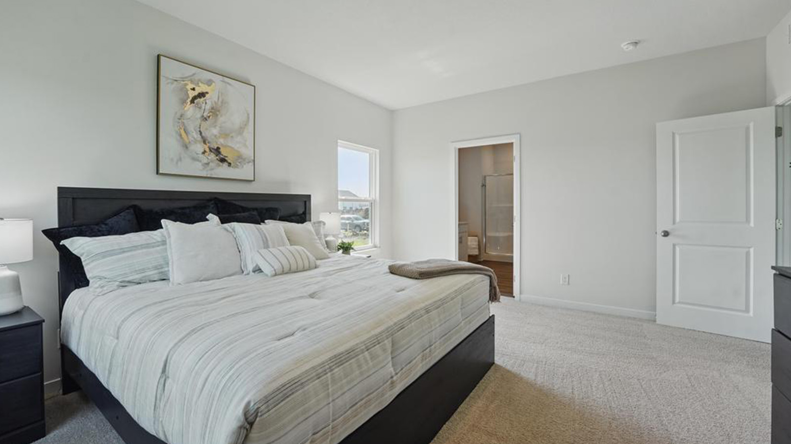 Carpeted primary bedroom with large windows