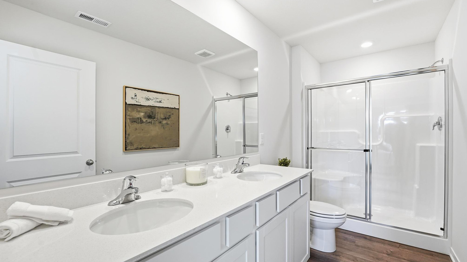 Primary bathroom with double sink vanity, standing glass door shower