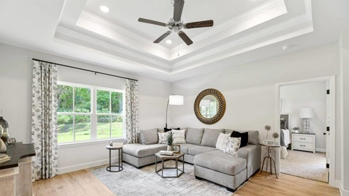 Living room with tray ceiling and ceiling fan