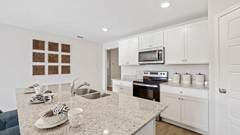 Gorgeous open kichen with large island and white cabinets