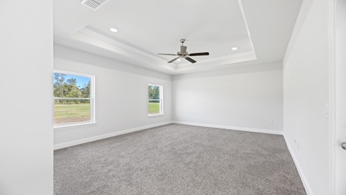Primary bedroom with trey ceilings