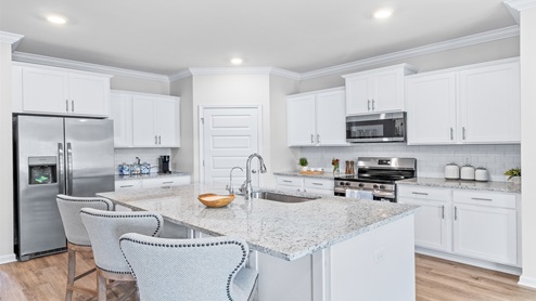 Kitchen with white cabinets and large granite island