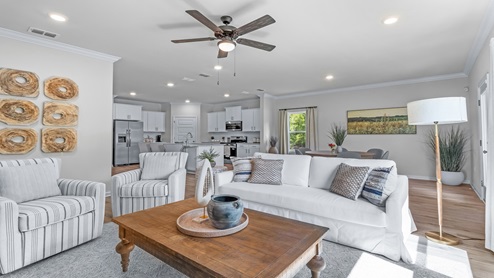 Living room of model home with couch and chairs