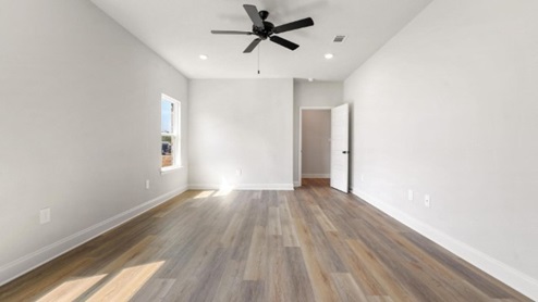 primary bedroom with hardwood floors, windows, recessed lighting, and ceiling fan