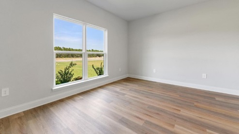 guest bedroom with hardwood floors and window