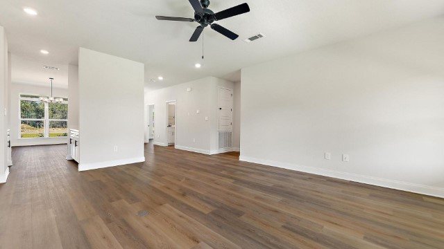 spacious living space with hardwood floors and ceiling fan
