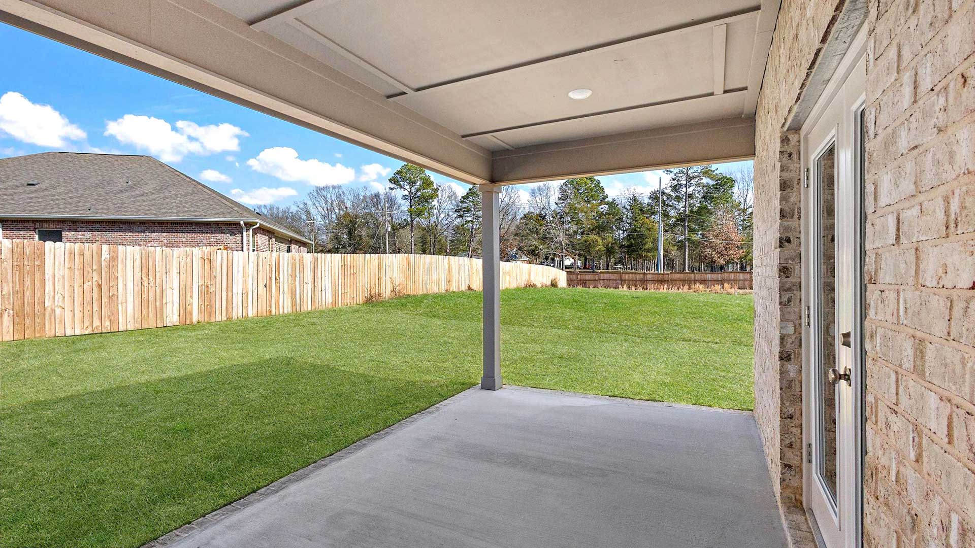 Private backyard featuring covered concrete patios with space for seating and grill setup Horseshoe Bend By D.R. Horton