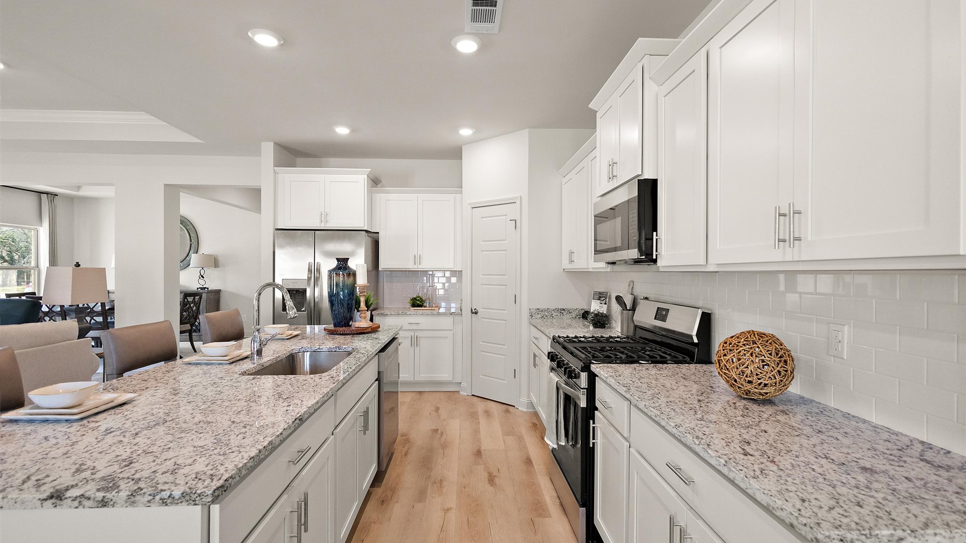 Other side view of kitchen with cabinets, dining, living areas, pantry, outside access, appliance suite included