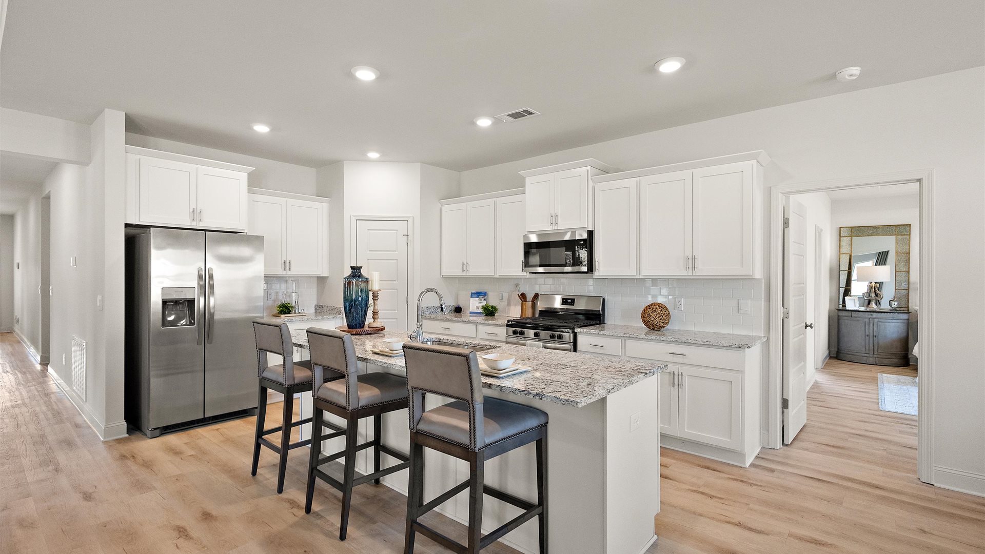 Kitchen island with sink, seating, pantry, cabinets, new appliance suite included, and multiple prep zones