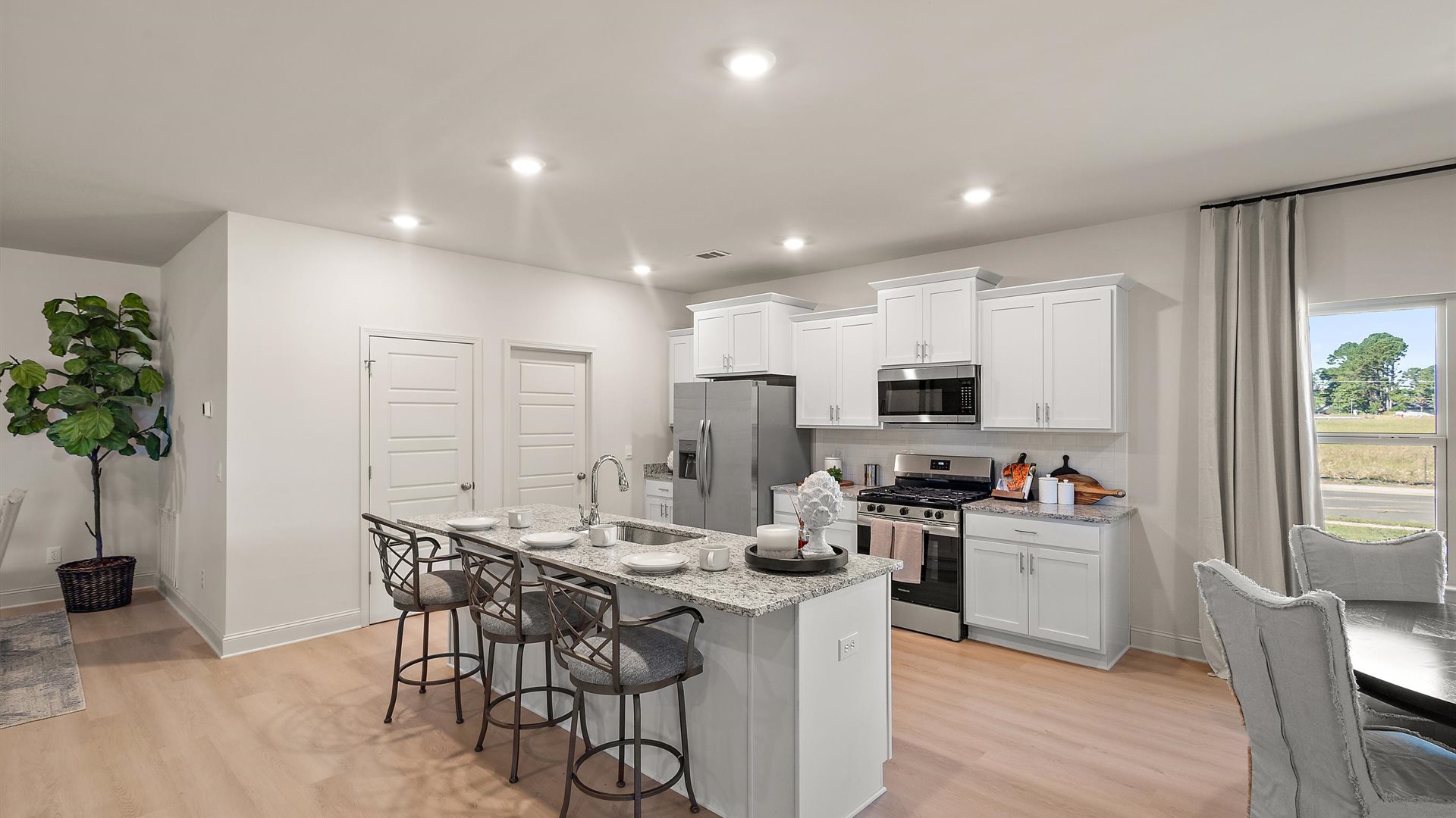 Spacious kitchen with granite countertops, island, and stainless-steel appliances.