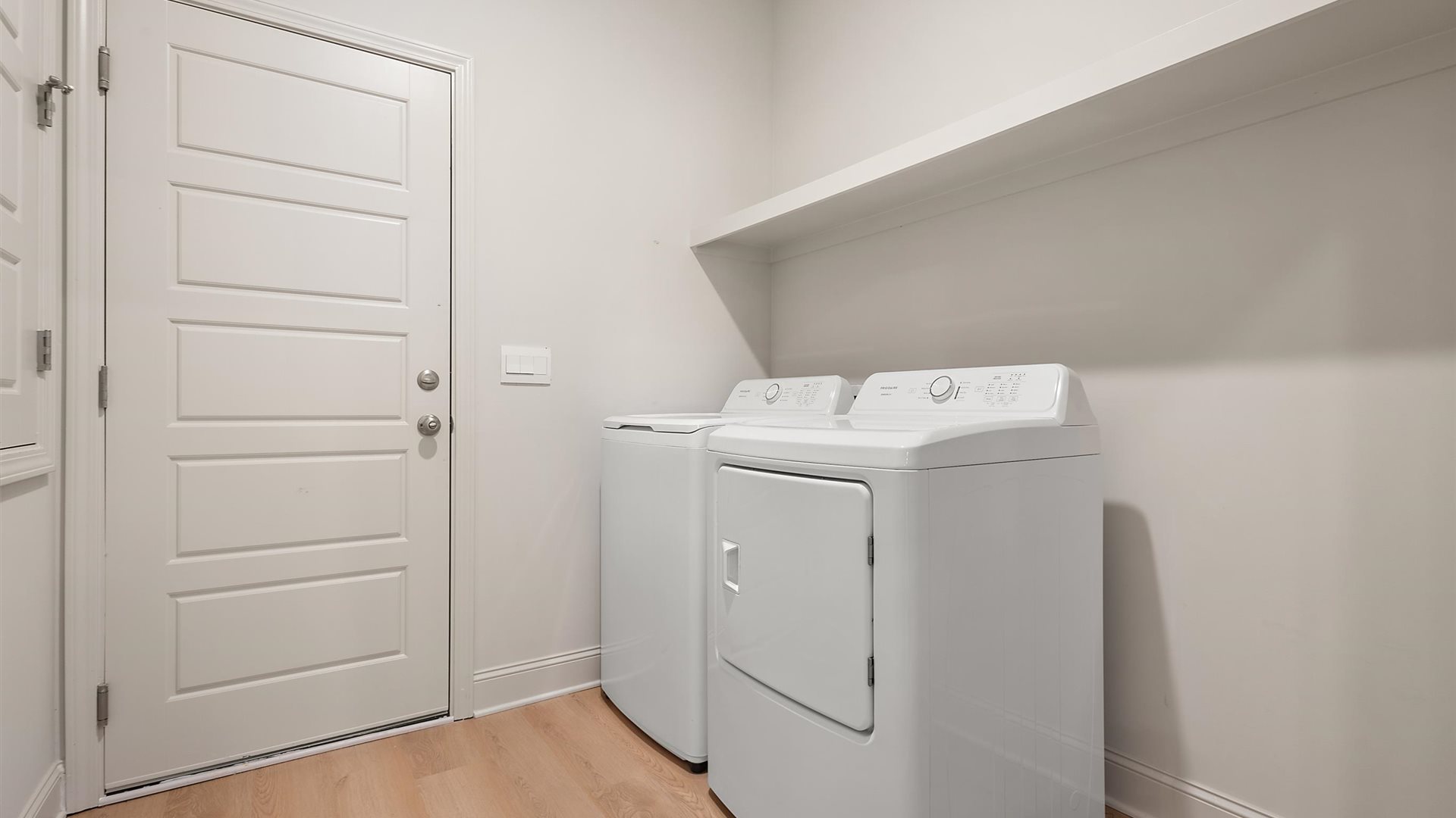 Laundry room with wooden shelving