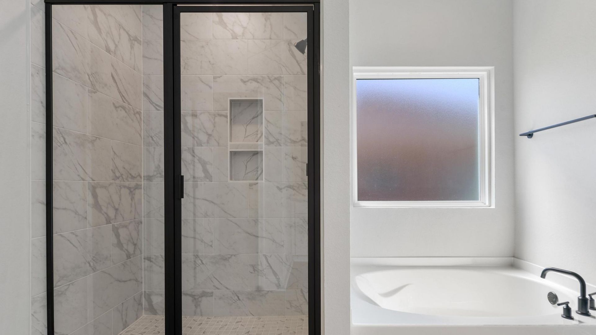 walk in show adjacent from garden tub with frosted window