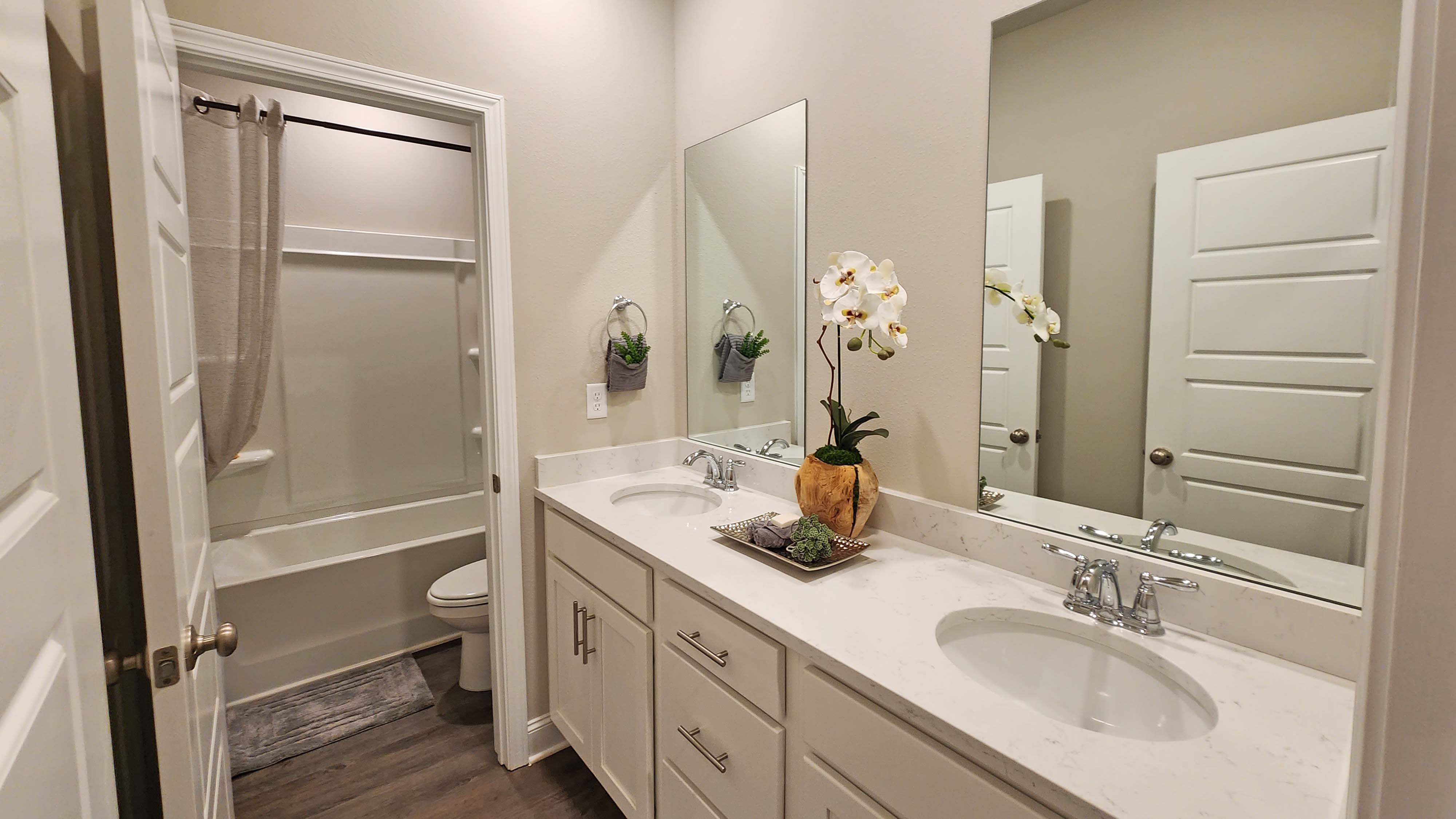 bathroom with dual vanity and shower/tub combo