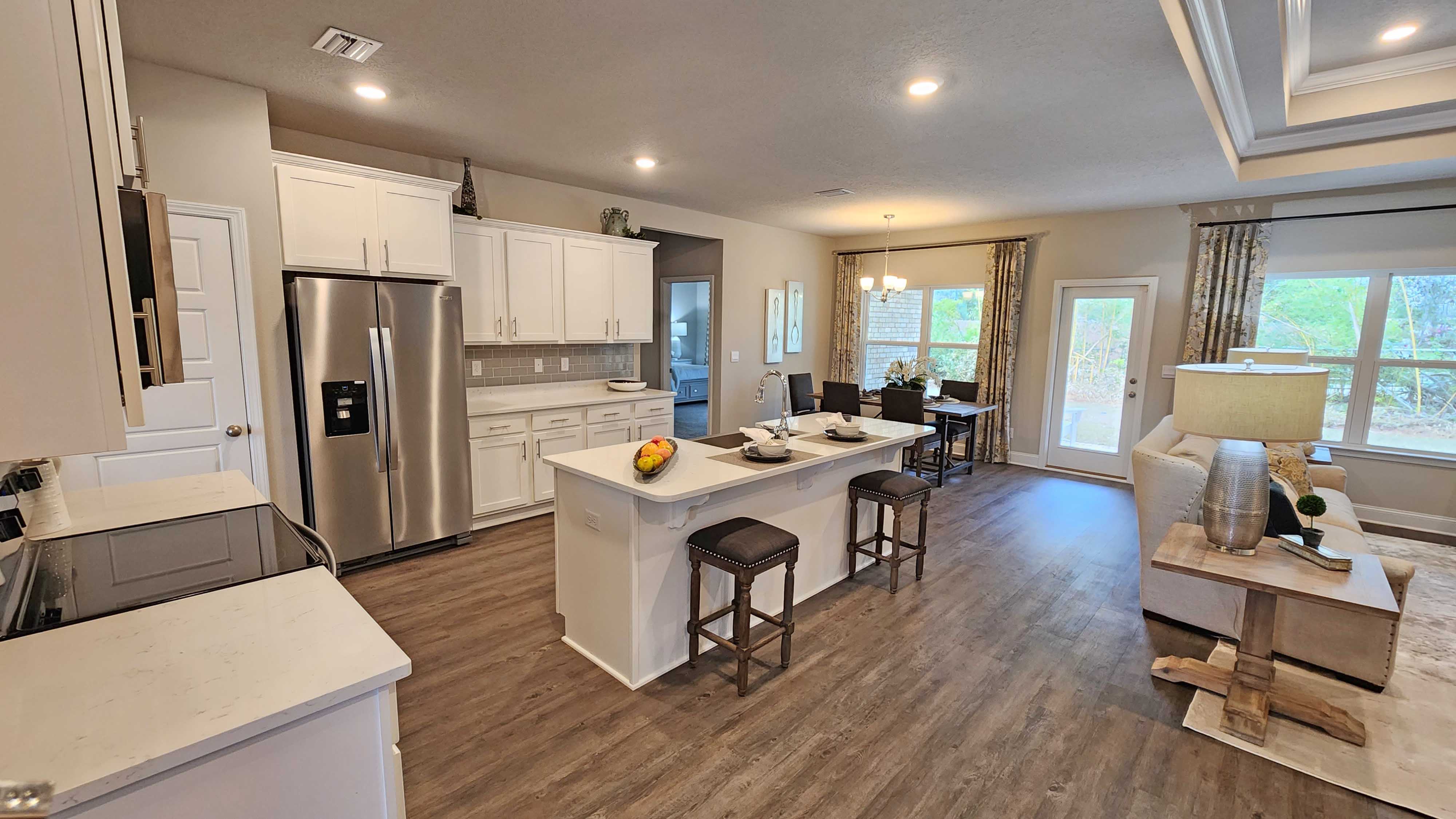 kitchen overlooking the living space with hardwood floors and recessed lighting
