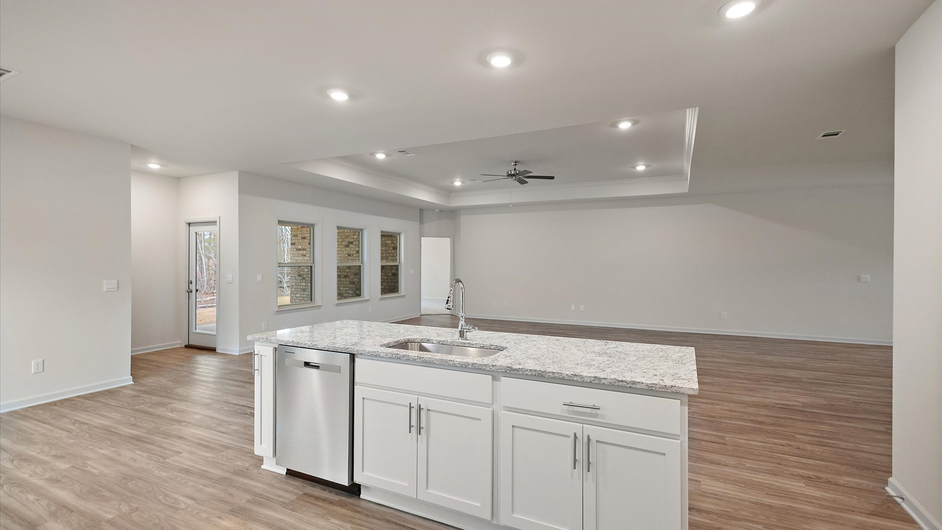 Spacious kitchen with granite countertops, island, and stainless-steel appliances.