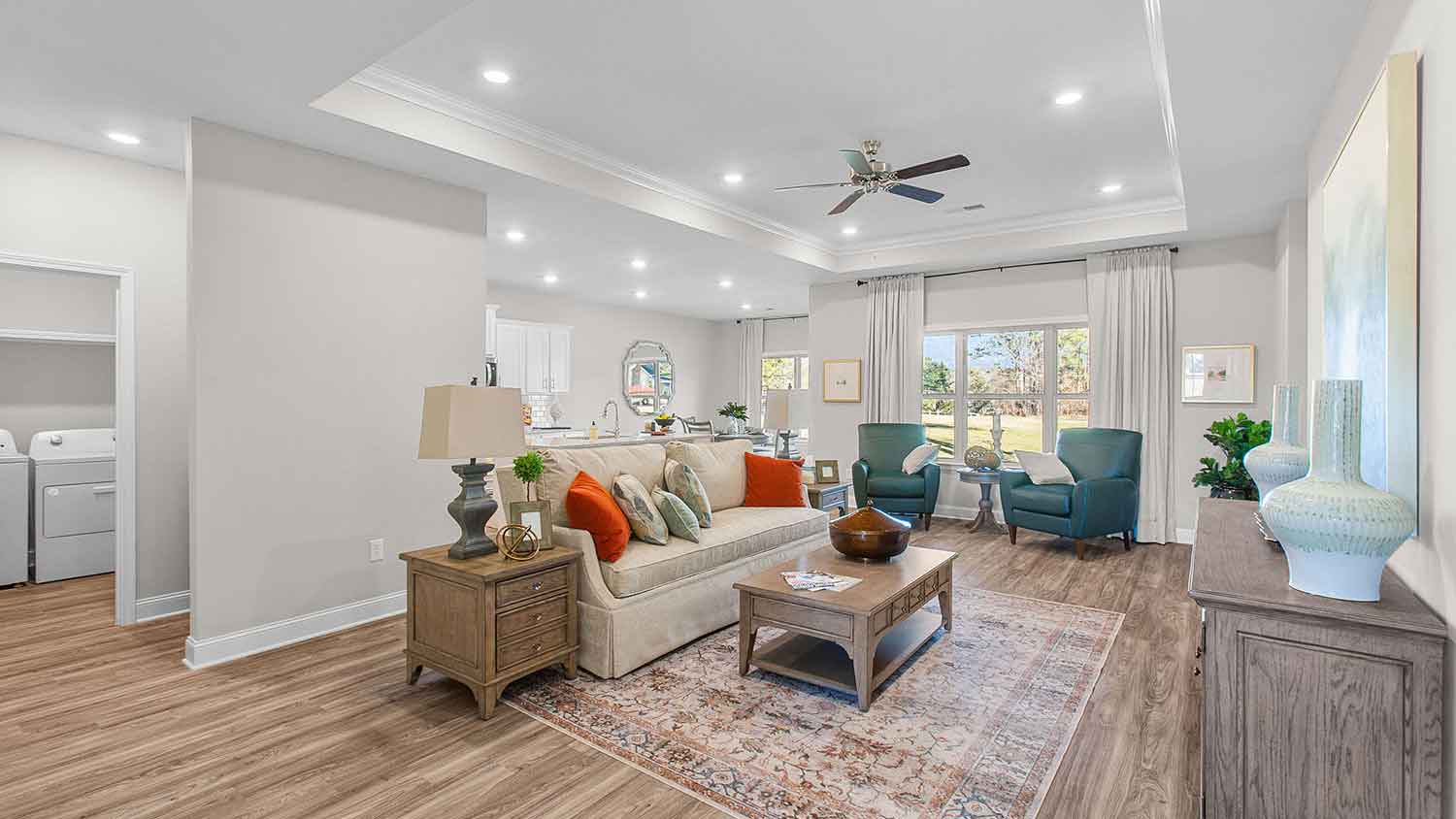 spacious living room featuring a beige sofa, and teal accent chairs