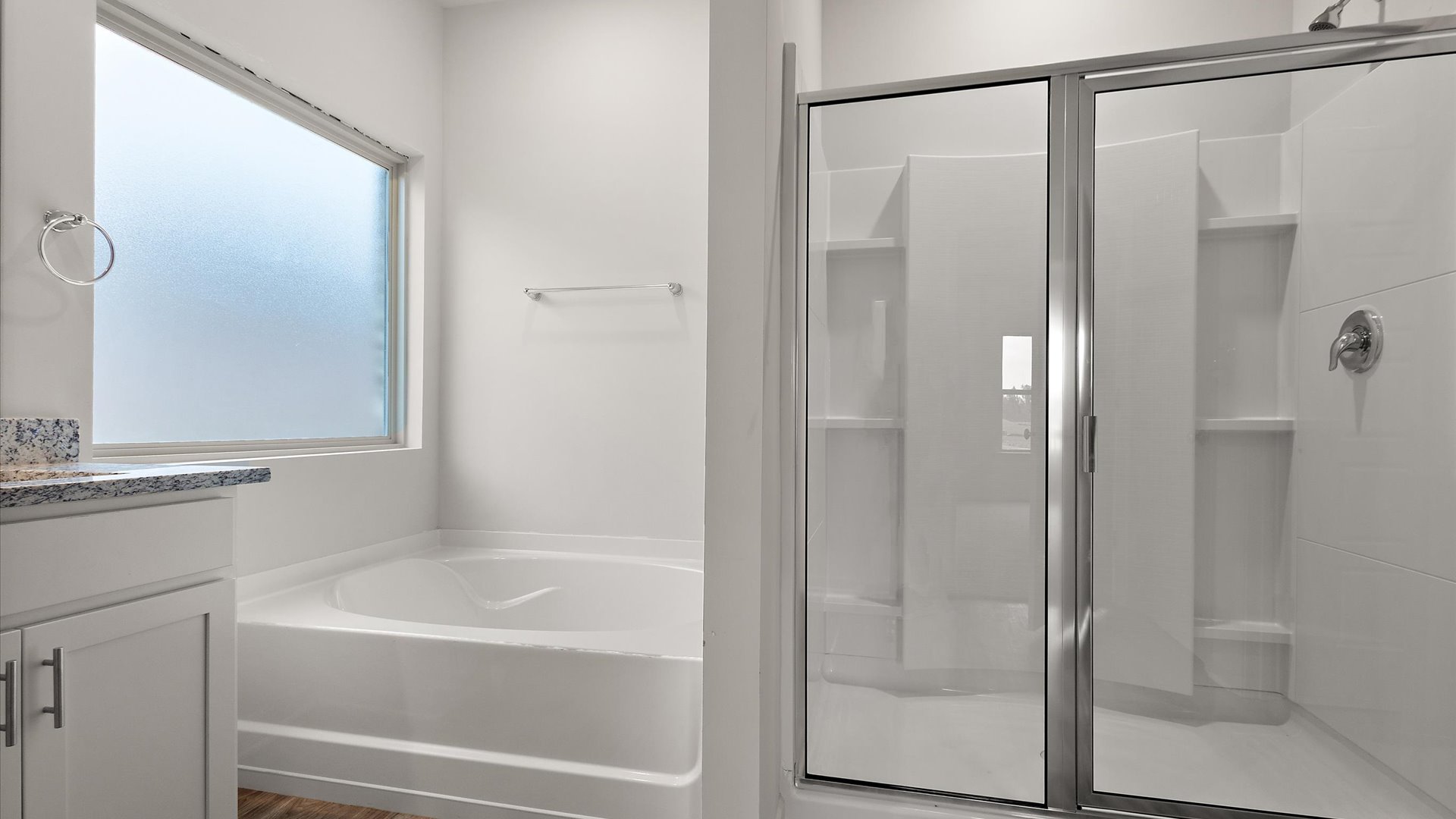 Walk in shower with built in shelving and garden tub with frosted window