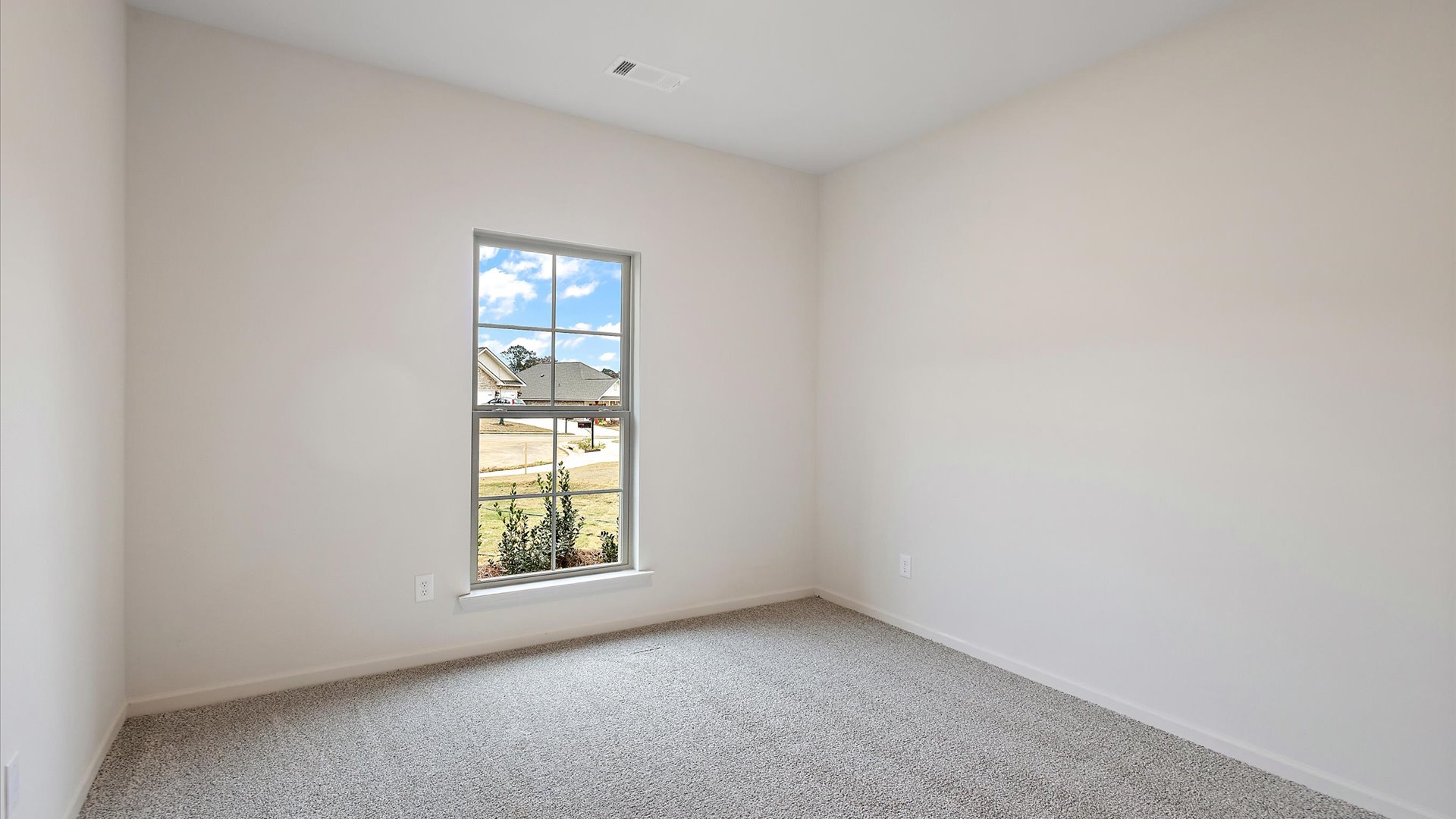 Additional bedroom with window and carpeted floors