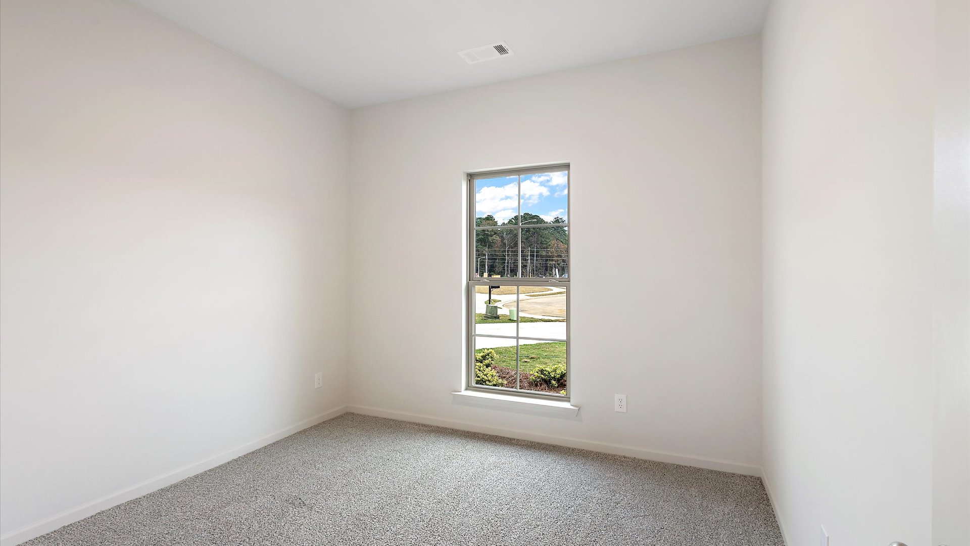 Additional bedroom with window and carpeted floors