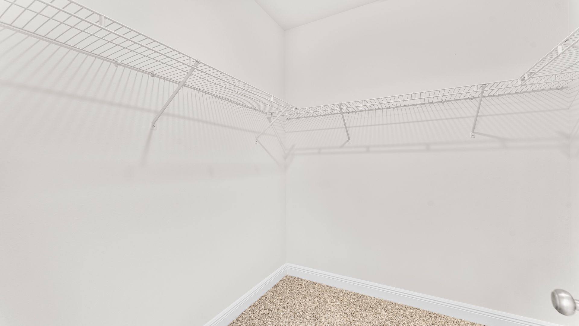 Spacious walk in closet with wood shelving.