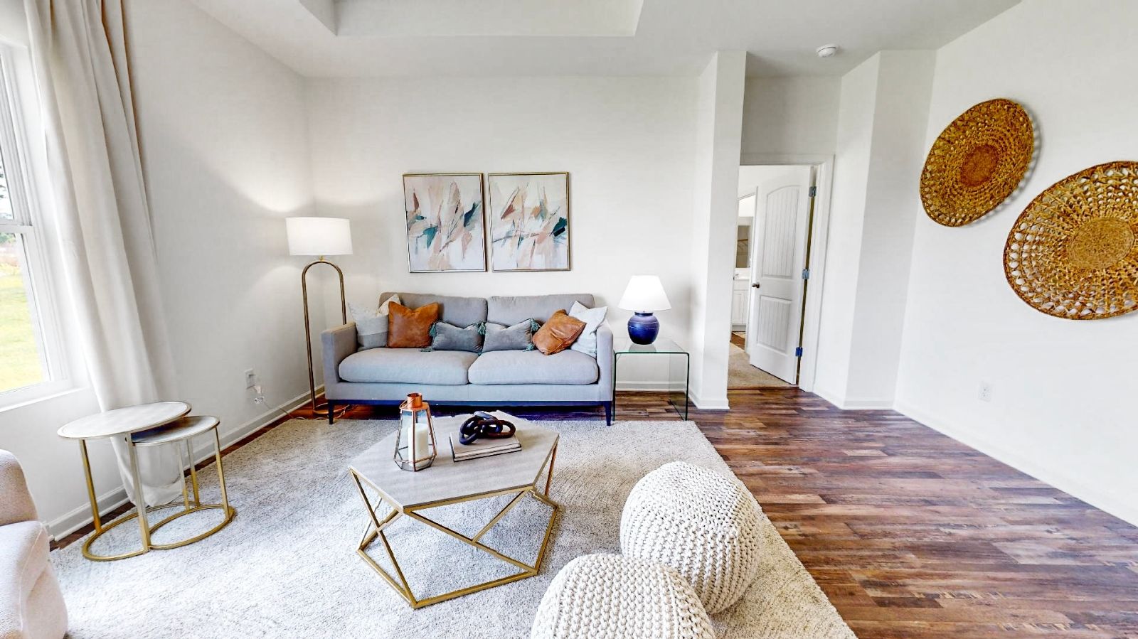 Living room with hardwood floors, trey ceiling, large windows for natural light.