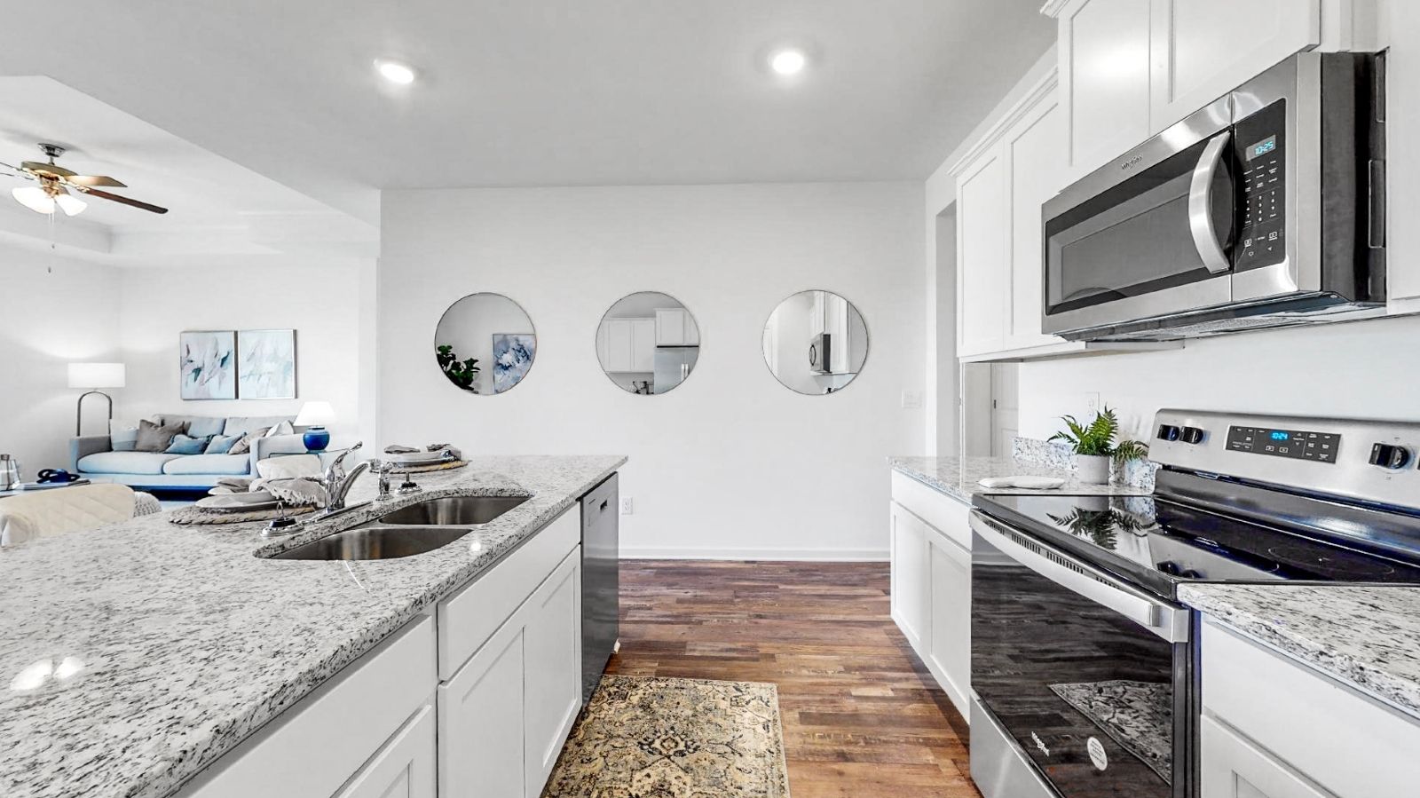 The single-story home plan has a spacious kitchen and island with granite countertops and appliances.