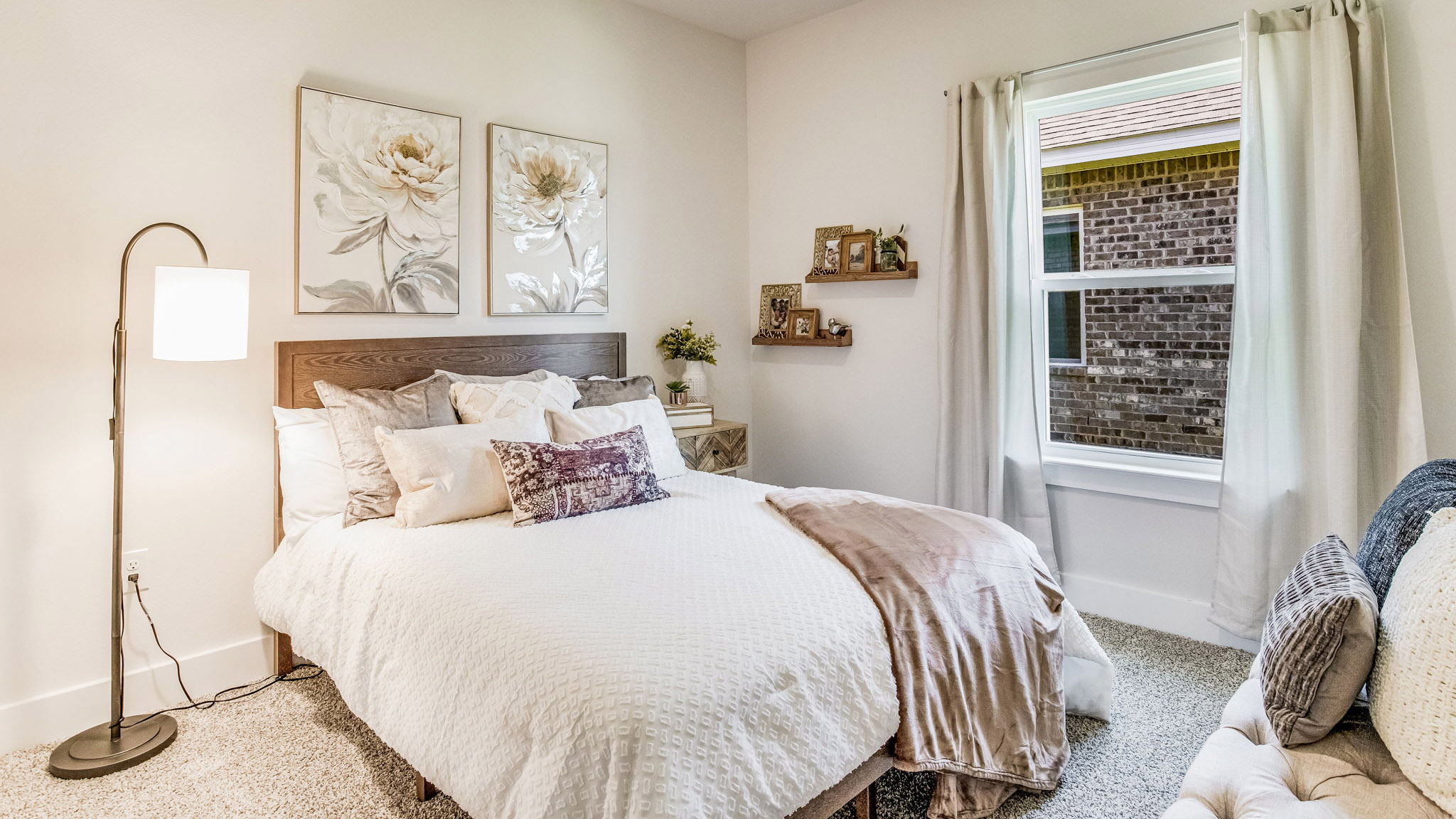 Bedroom with single window and carpeted floors.