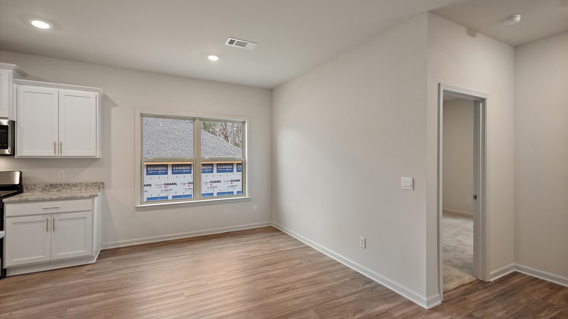 Breakfast nook area with recessed lighting with hardwood floors.