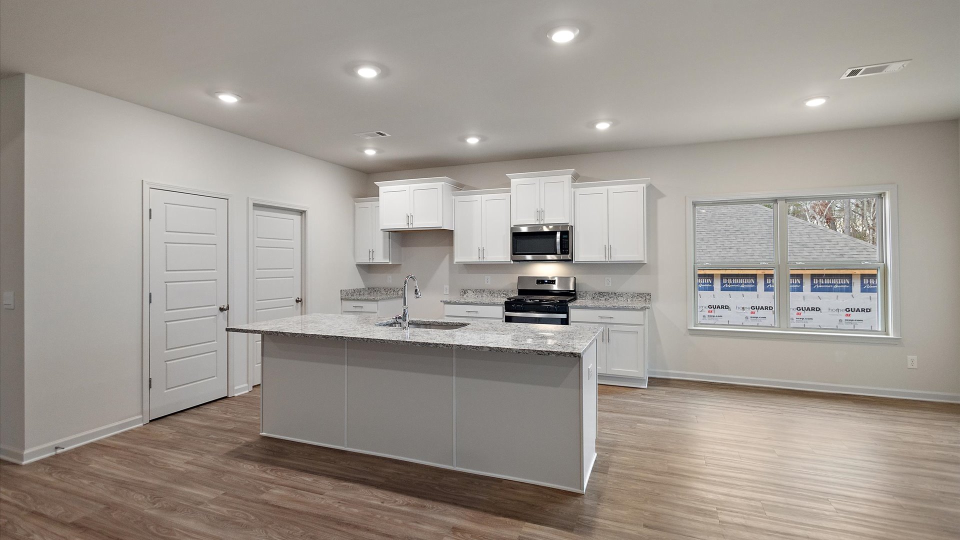 Spacious kitchen with granite countertops, island, and stainless-steel appliances.
