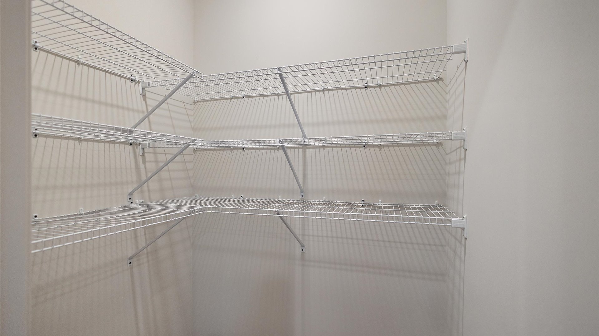 Pantry with wire shelving and recessed lighting.