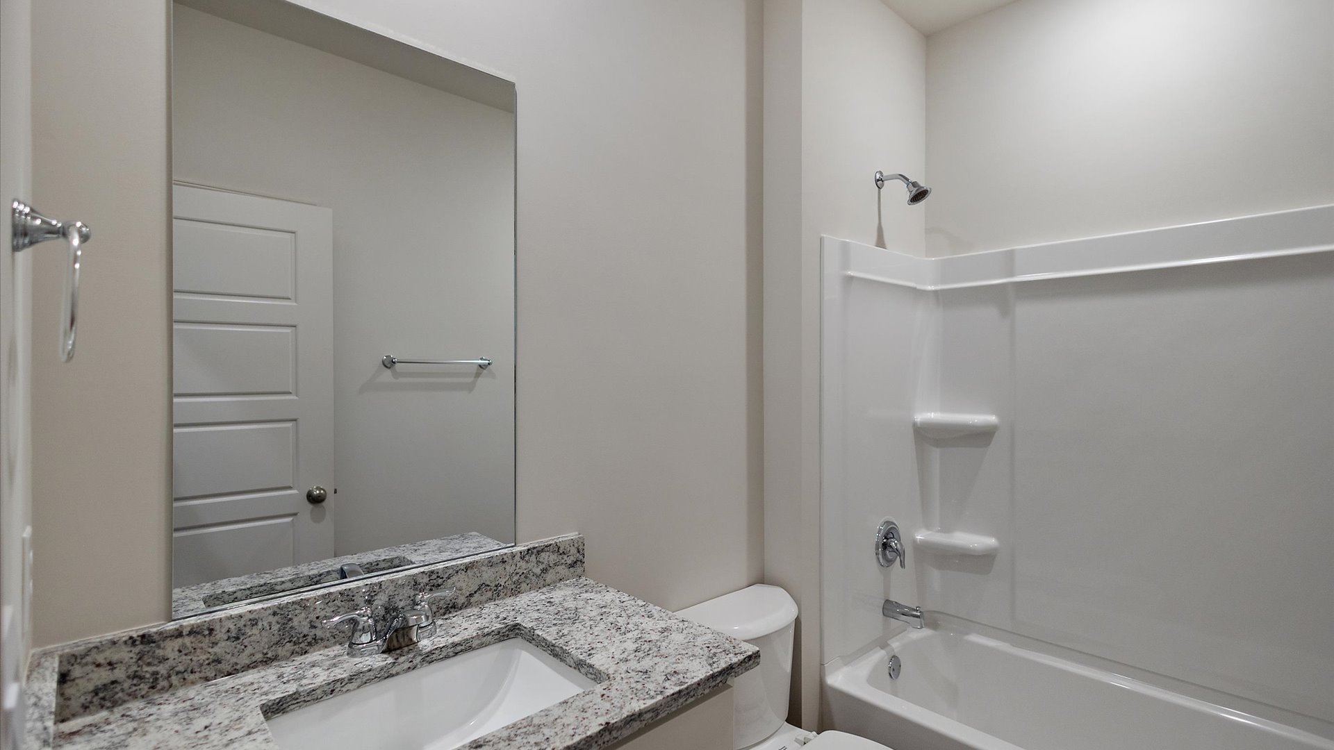 Single vanity bathroom with shower and tub combination.