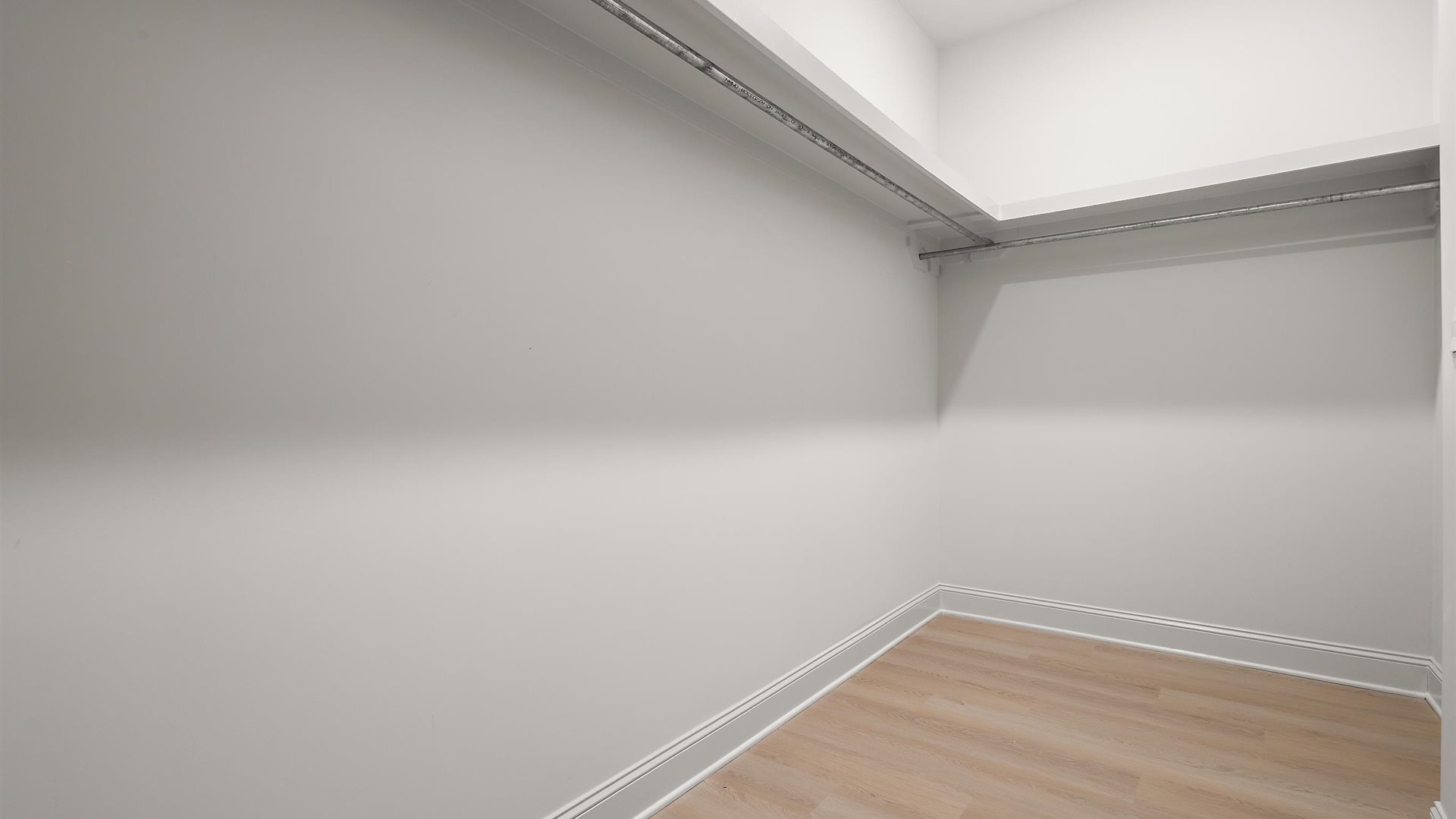 Walk in closet with wooden shelving