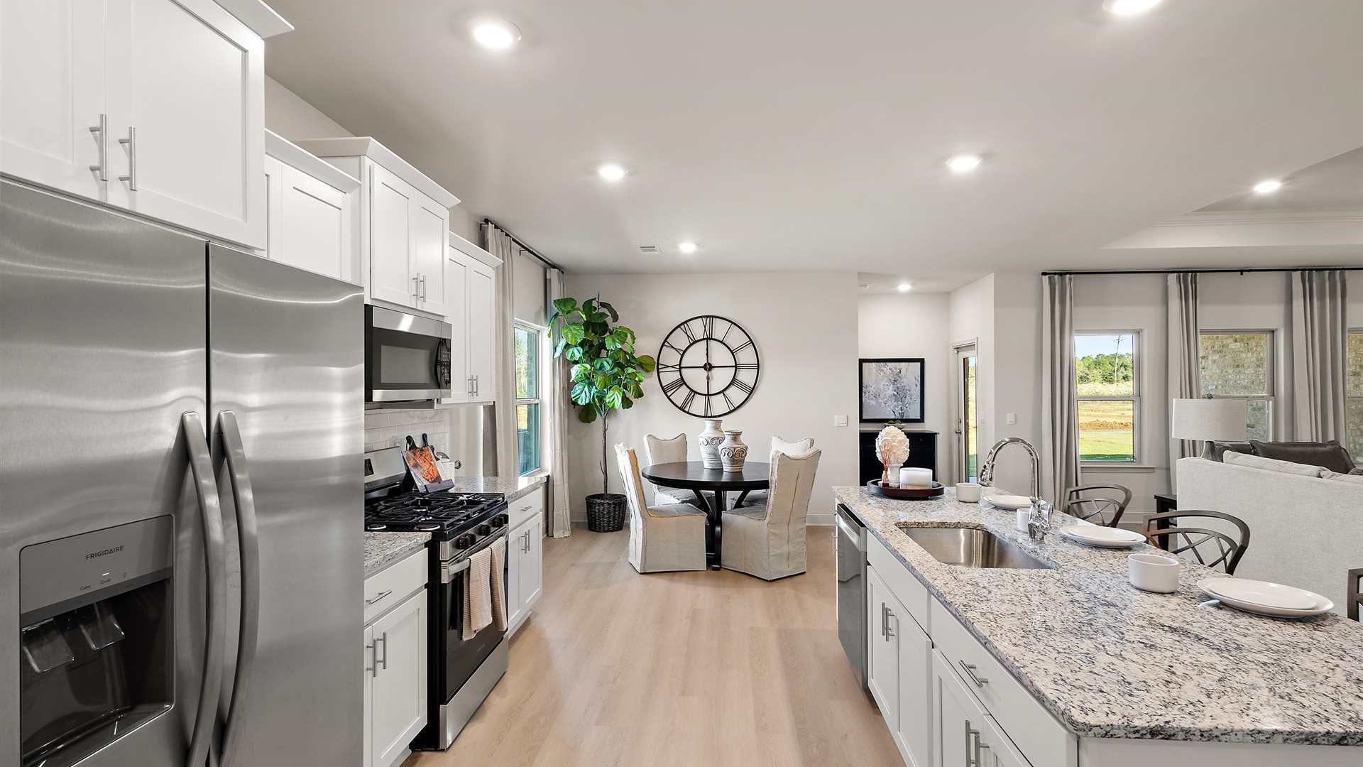 Spacious kitchen with granite countertops, island, and stainless-steel appliances.