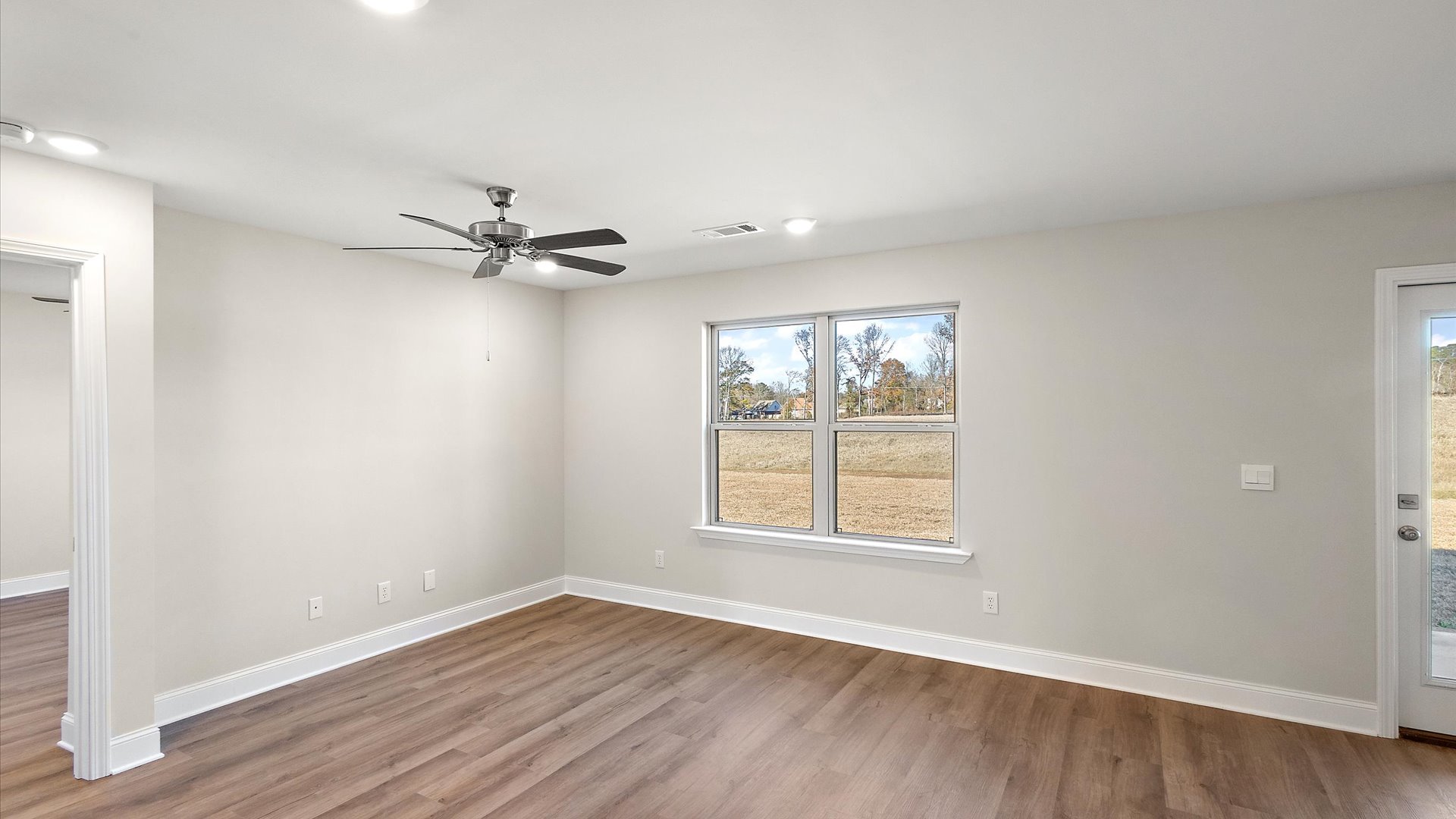 main living space with hardwood floors, windows, recessed lighting, and ceiling fan.