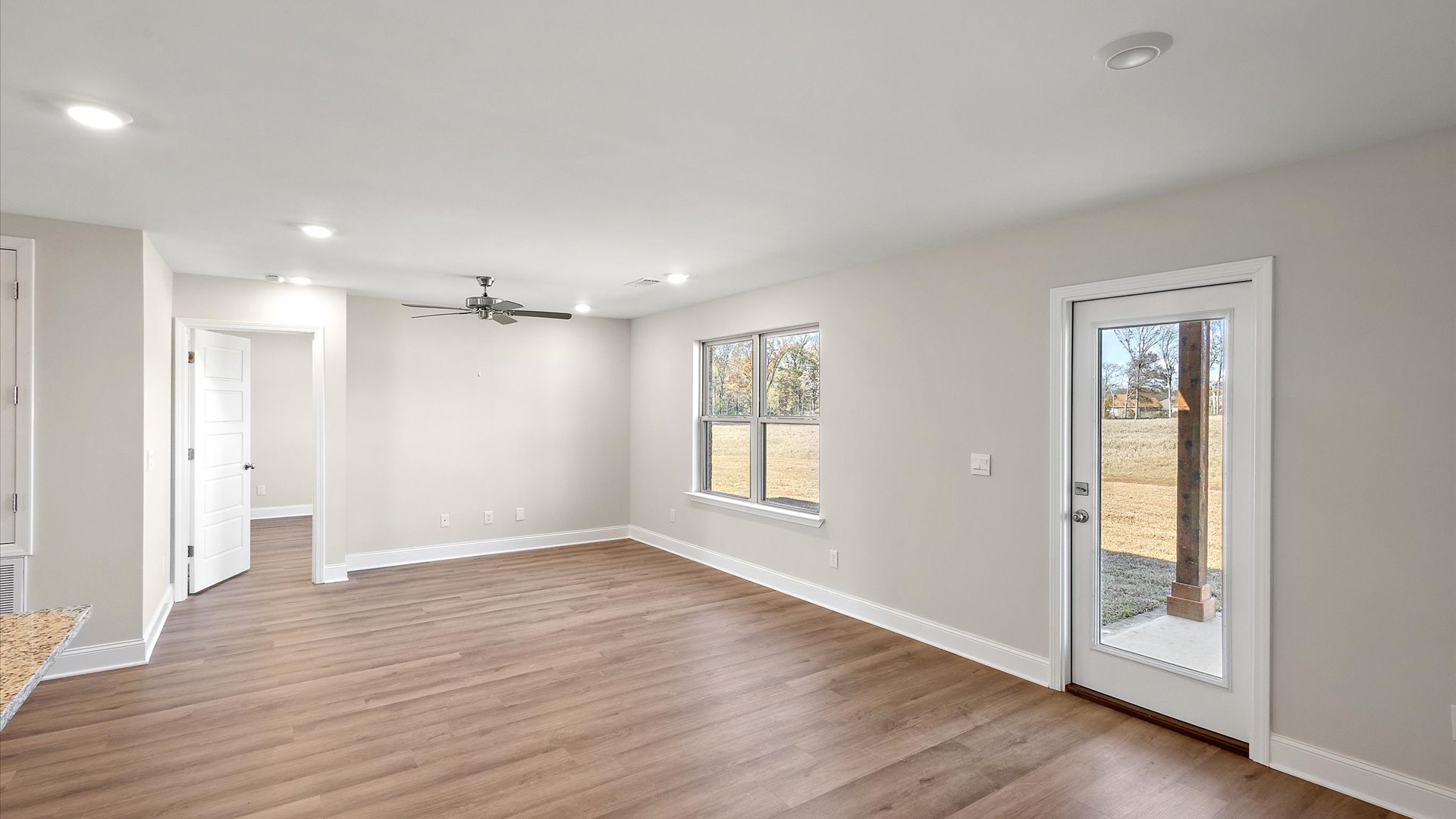 main living space with hardwood floors, windows, recessed lighting, ceiling fan and access to covered porch.